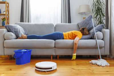 Low section of woman with towels on sofa at home