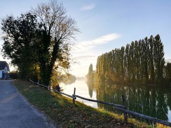 Footpath by river against sky