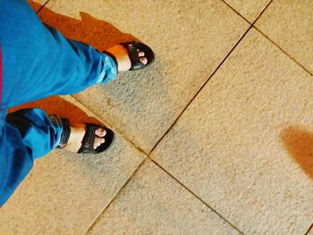 Low section of child standing on tiled floor