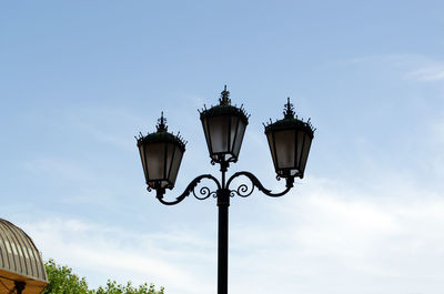Low angle view of electric lamp against sky