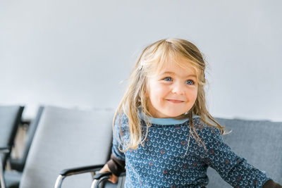 Cute smiling girl looking away while sitting at home