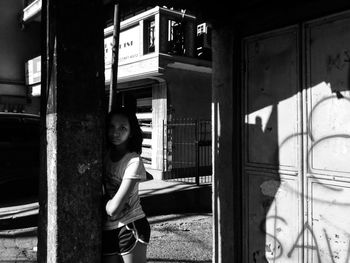 Portrait of woman standing by building