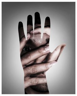 Double exposure of man and hand against gray background