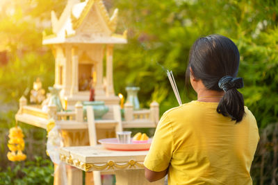 Rear view of woman sitting on table