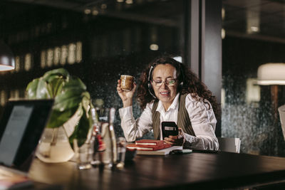 Portrait of a smiling young woman using phone