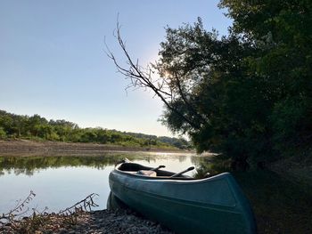 Boat moored on lake against sky