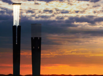 Silhouette of wooden post against sky during sunset