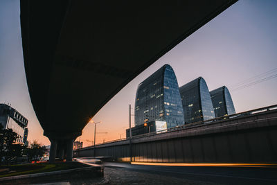 Low angle view of bridge and buildings against sky in city