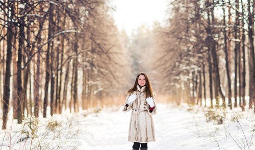 Woman standing on snow covered land