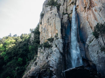 Low angle view of waterfall against sky