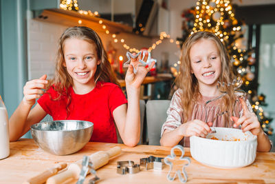 Cute girls making cookies on table