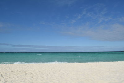 Scenic view of beach against blue sky