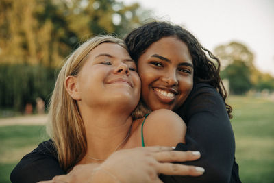 Happy teenage girl hugging female friend with eyes closed