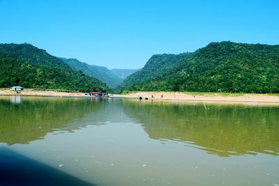 Scenic view of lake and mountains against clear sky