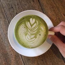 High angle view of woman holding cappuccino