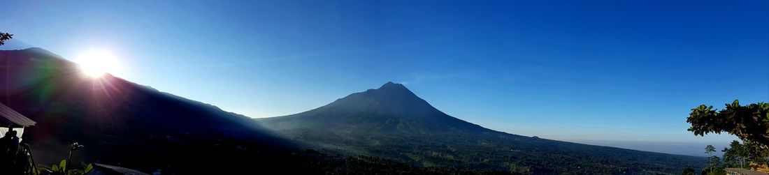 Scenic view of mountains against blue sky