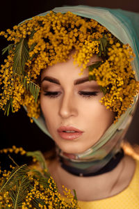 Portrait of a young woman in yellow mimosa flowers