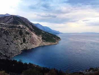 Scenic view of sea and mountains against sky