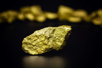 Close-up of lemon slice on rock against black background