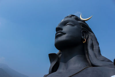 Low angle view of statue against clear blue sky