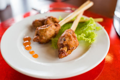 Meat on a lemongrass stick served with lettuce and hot chilli sauce. asian restaurant meal