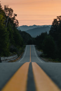 Surface level of road against sky during sunset