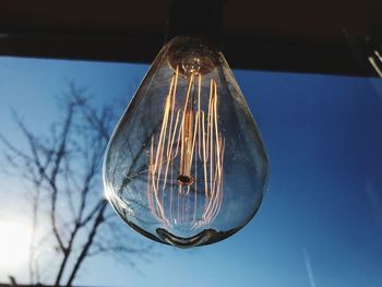 Low angle view of light bulb hanging from ceiling