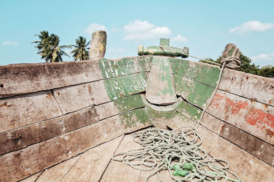 Damaged wall by trees against sky