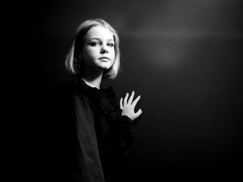 Portrait of a beautiful young woman against black background