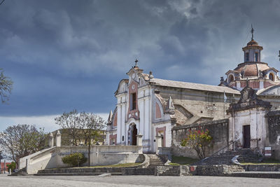 Low angle view of statue amidst buildings against sky