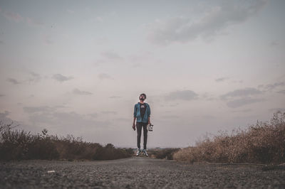 Full length of man levitating over road against sky