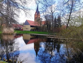 Reflection of building on lake against sky