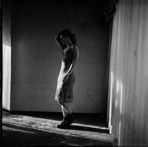 Portrait of woman standing against wall at home