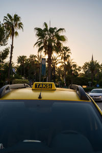 Selective focus of a taxi sign on a yellow car in turkey against palm trees