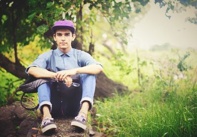 Portrait of a man sitting on tree