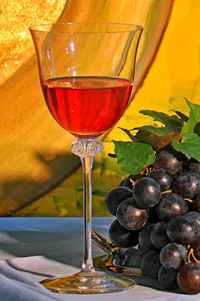 Close-up of wine with grapes served on table
