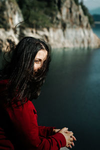 Young woman standing by lake