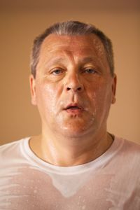 Portrait of sweaty man on beige background