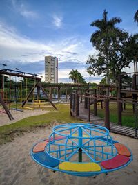 Park by swimming pool in city against sky