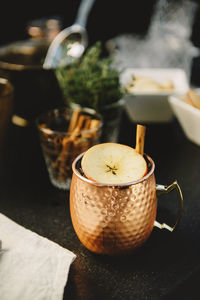 Close-up of drink garnished with apple slice and cinnamon