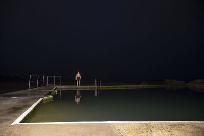 Sportsman standing at poolside during dawn
