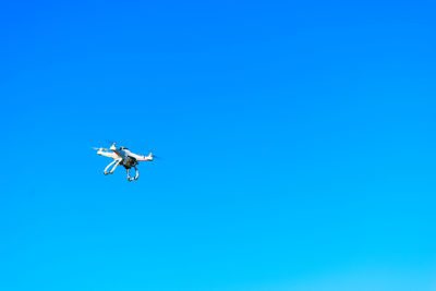 Low angle view of airplane against clear blue sky