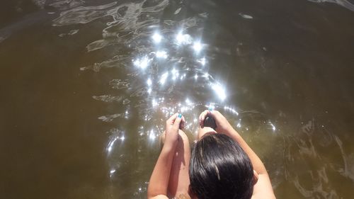 Rear view of woman swimming in water