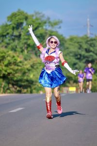 Full length of woman with umbrella on road