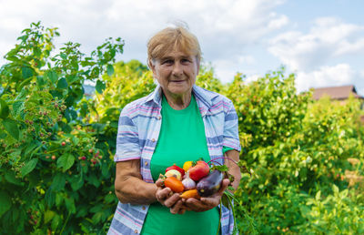 Portrait of smiling female farmer holding vegetables