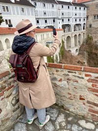 Low angle view of woman standing against stone wall