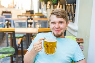 Portrait of a smiling young man sitting in restaurant