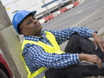 Side view of man sitting on street