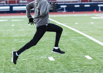 Low section of man playing soccer on field