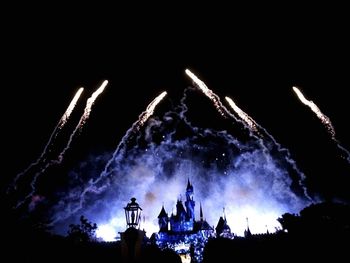 Low angle view of fireworks against sky at night